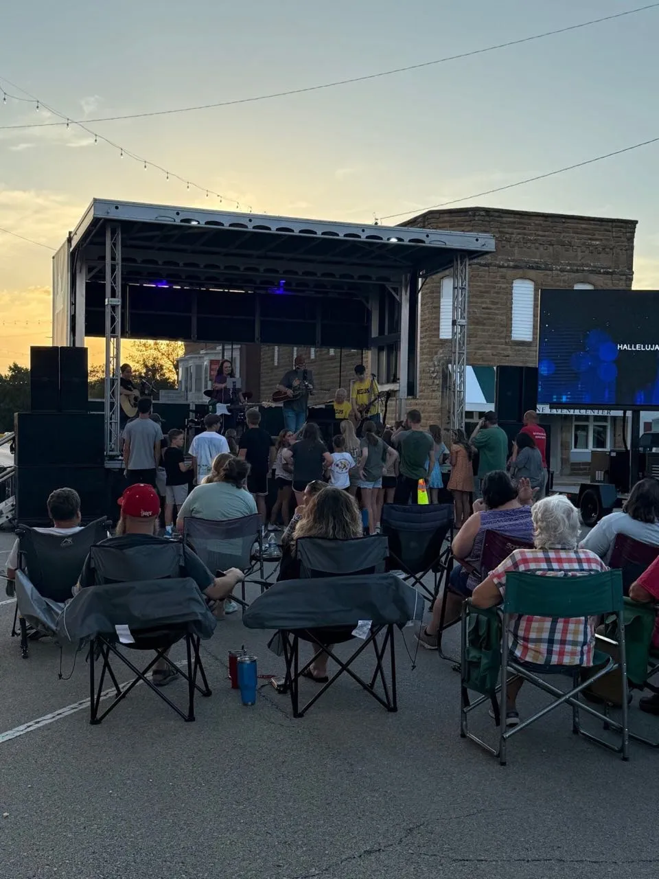 Sunset street concert crowd facing an LED screen at a Phase 3 Live production