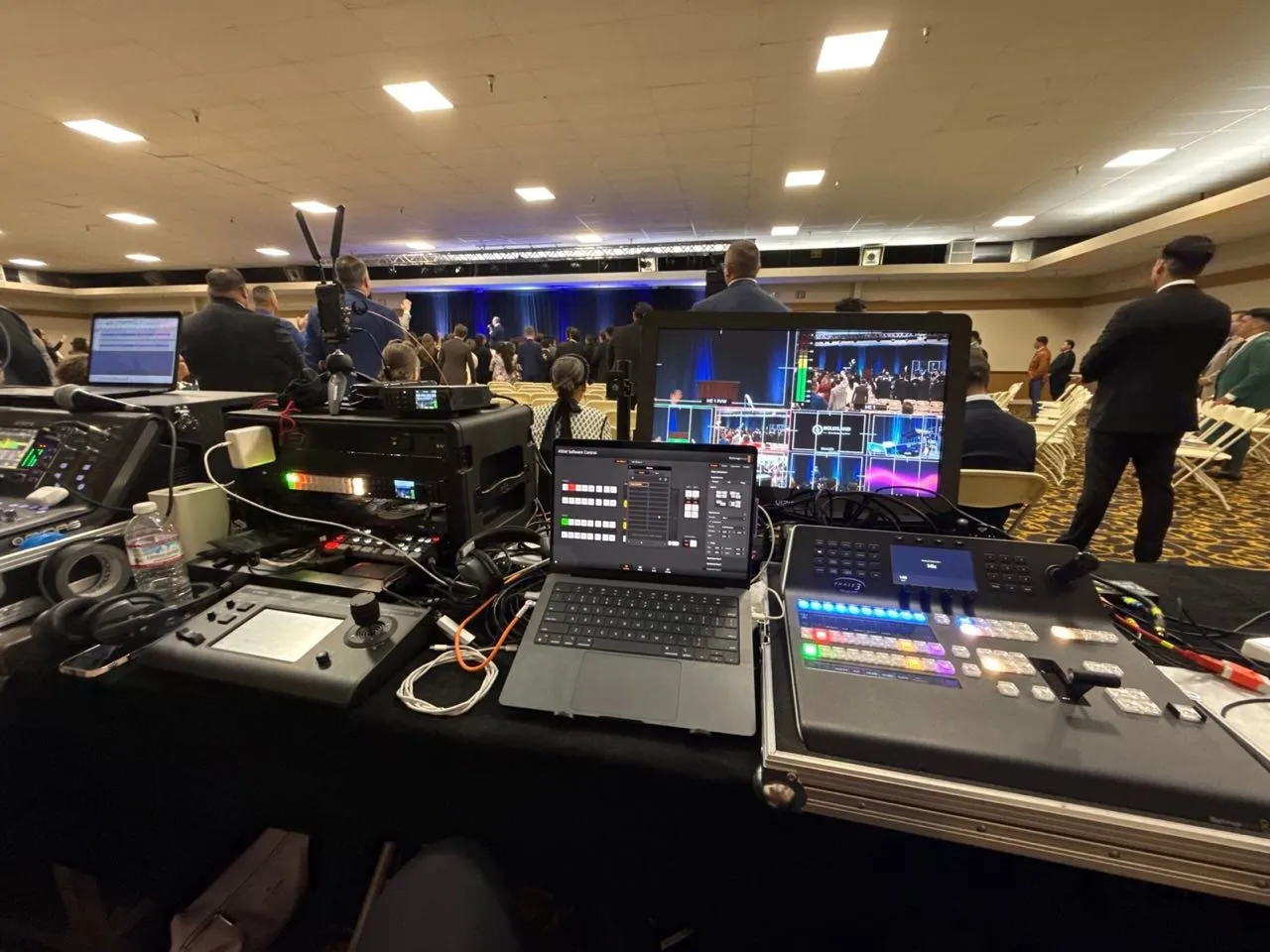 Phase 3 Live video control station with switcher and monitors at the back of a conference ballroom