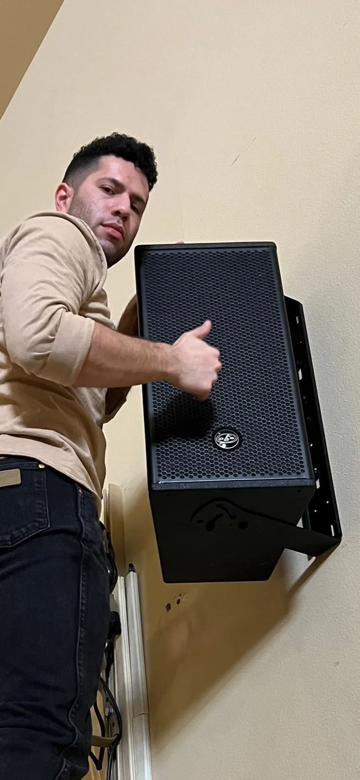 Phase 3 Live technician wall-mounting a DAS Audio loudspeaker during an install