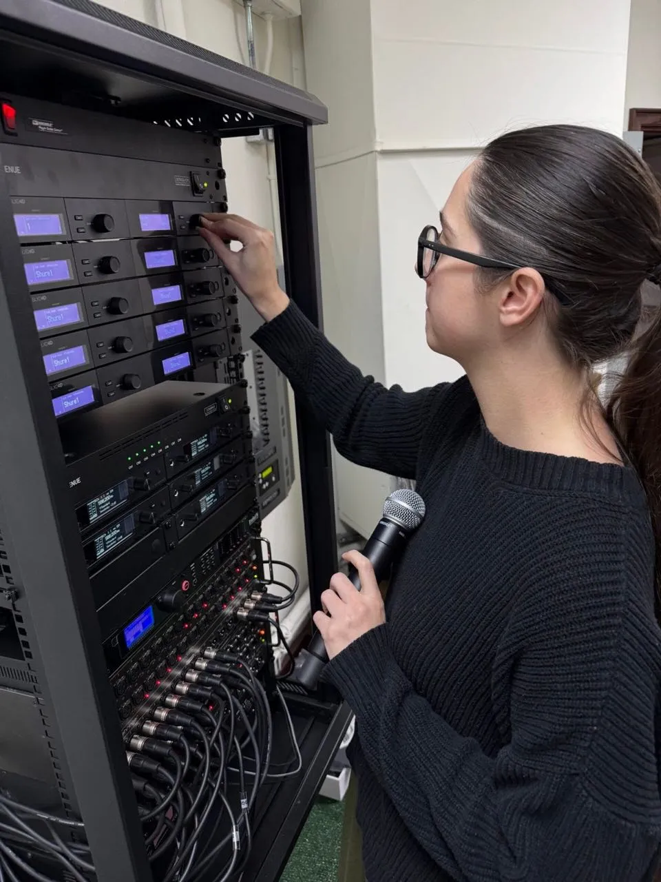 Phase 3 Live technician dialing in wireless microphone receivers in an equipment rack
