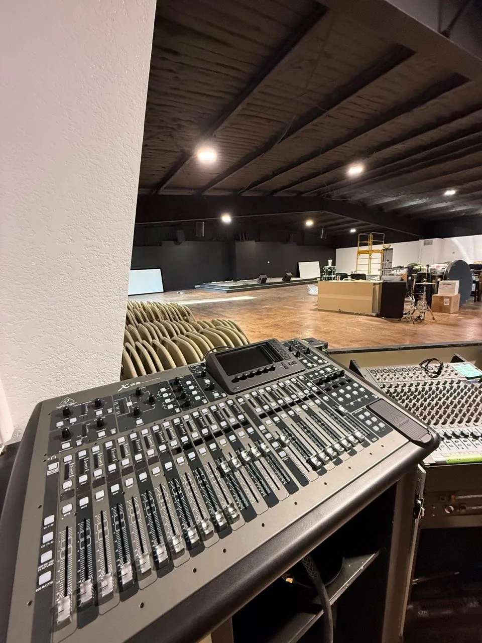 Digital mixing console at a balcony front-of-house position overlooking a venue in progress